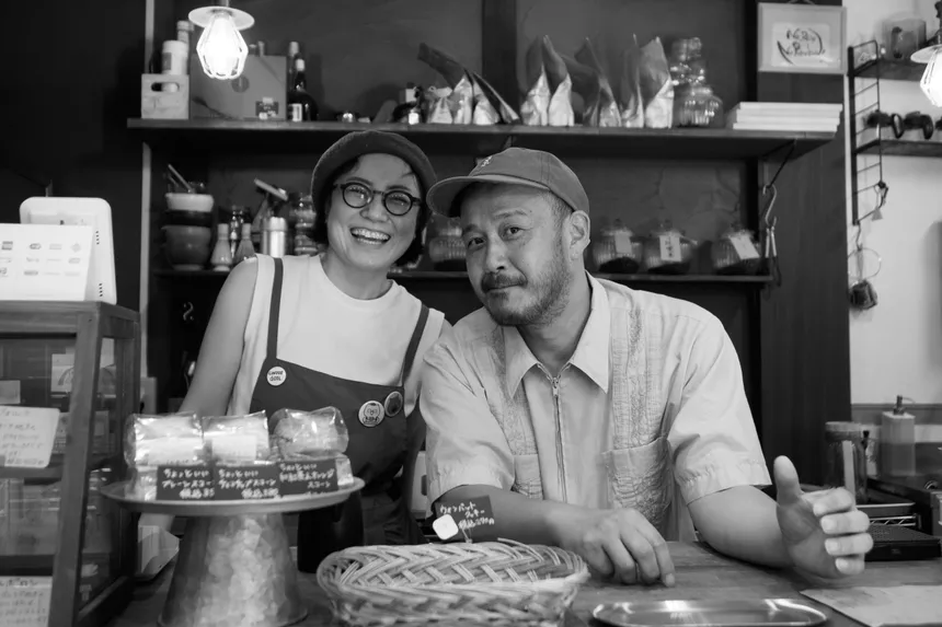 La pareja que lleva Suzumesya sonríe detrás de la barra, rodeada de bollería y botes de café.